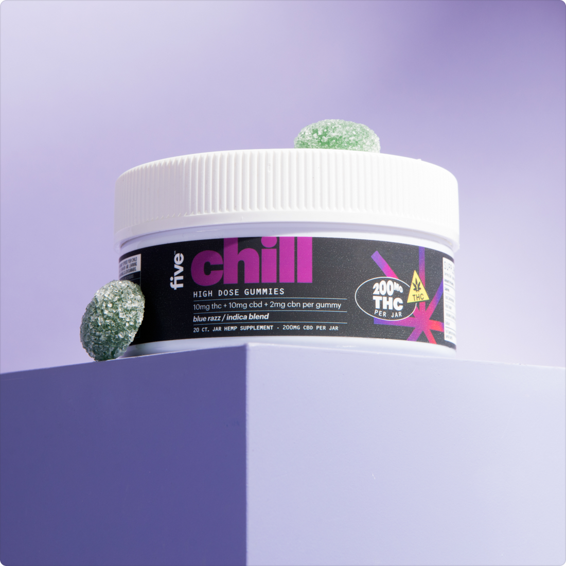 Front-angle of Five Chill high-dose THC gummy jar showing black label and two green sugar-coated gummies on a lavender pedestal